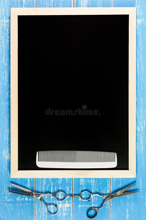 Blank blackboard and Hairdresser's scissors with comb on wooden royalty free stock image