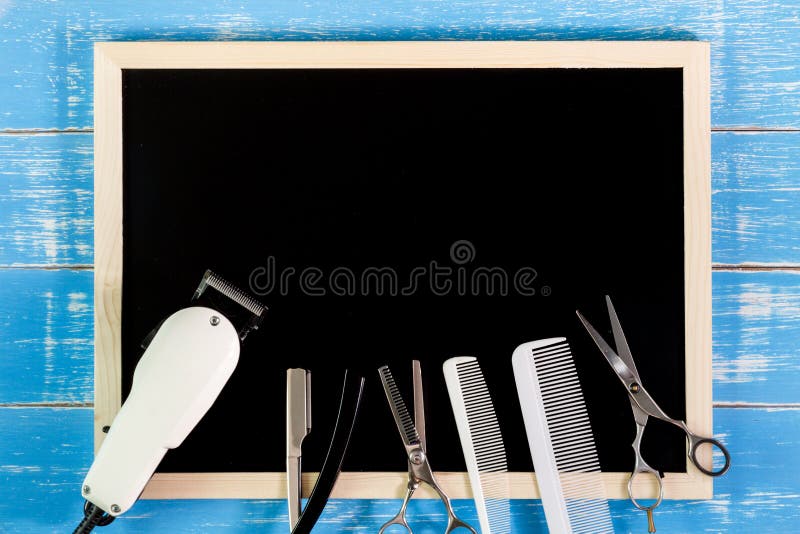 Blank blackboard and scissors hairdresser set with various accessories on wooden table. Template mock up for adding your design royalty free stock images