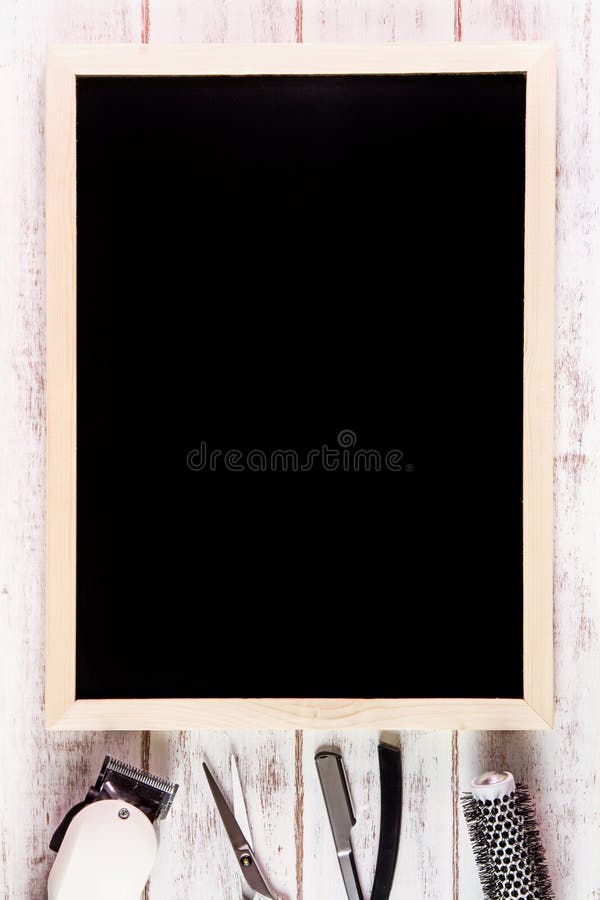 Blank blackboard and scissors hairdresser set with various accessories on wooden table. Template mock up for adding your design royalty free stock image