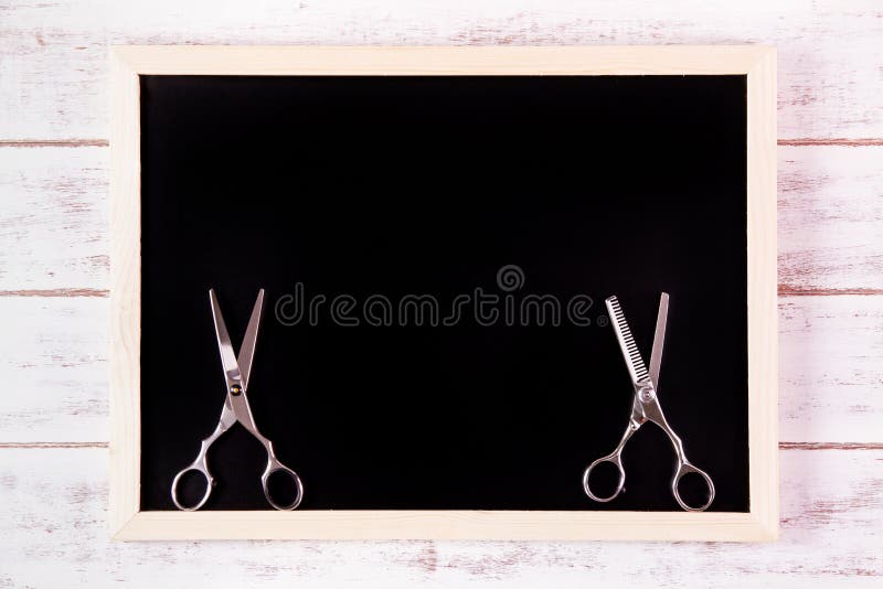 Blank blackboard and scissors hairdresser on wooden table. stock images