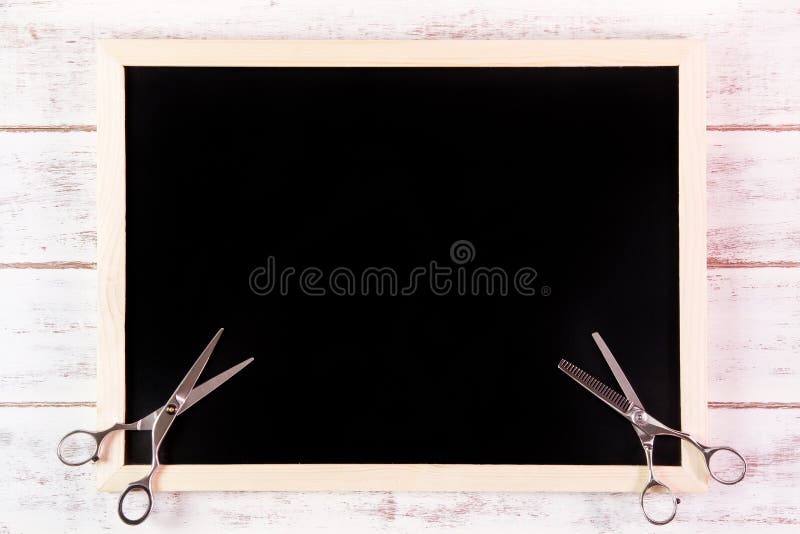 Blank blackboard and scissors hairdresser on wooden table. stock photography