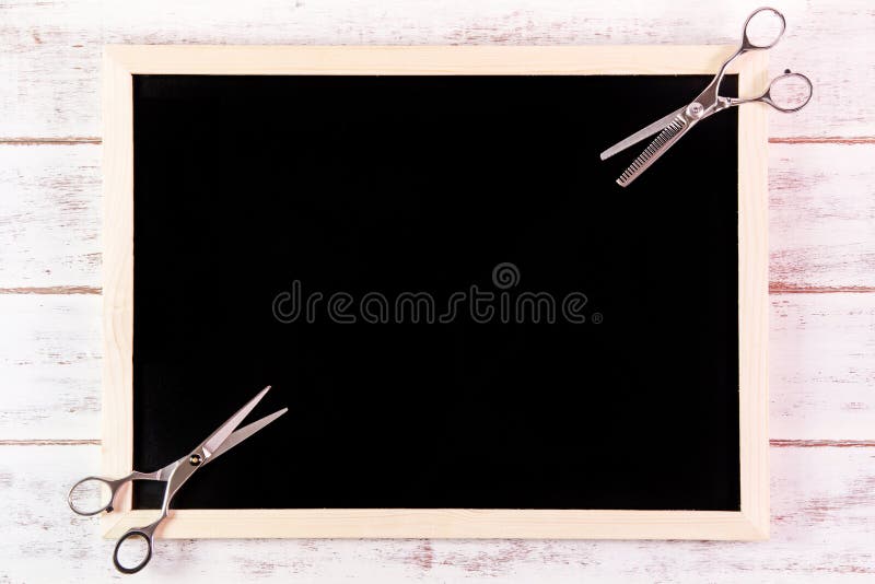 Blank blackboard and scissors hairdresser on wooden table. stock photo