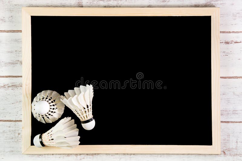 Blank blackboard and the Shuttlecock on wooden table. Template mo royalty free stock photo