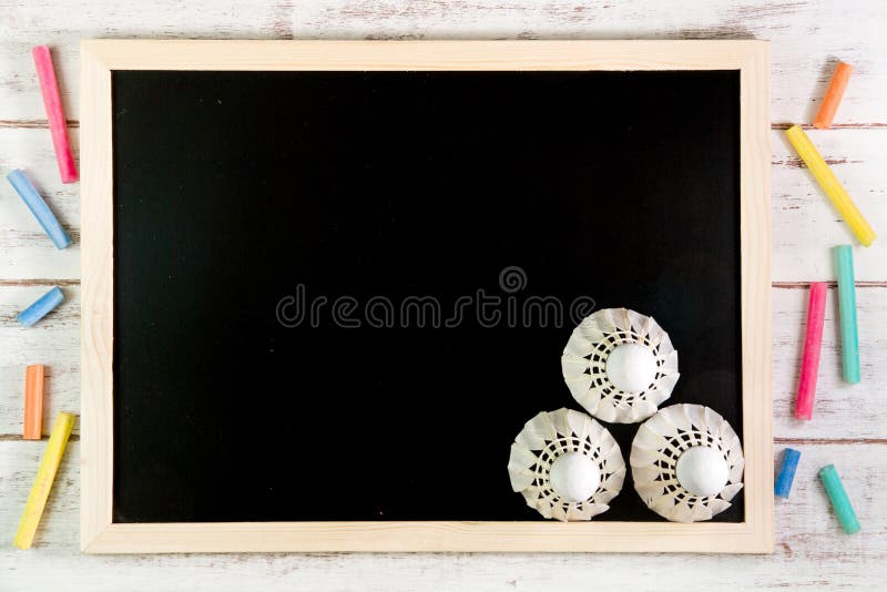 Blank blackboard and the Shuttlecock on wooden table. Template mo royalty free stock image