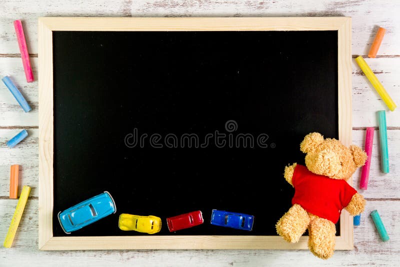 Blank blackboard, Teddy Bear and Car toys on wooden table. Template mock up for adding your design and leave space beside frame royalty free stock image