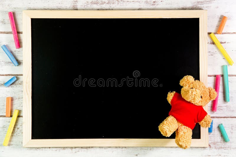 Blank blackboard and Teddy Bear on wooden table. Template mock up stock photo