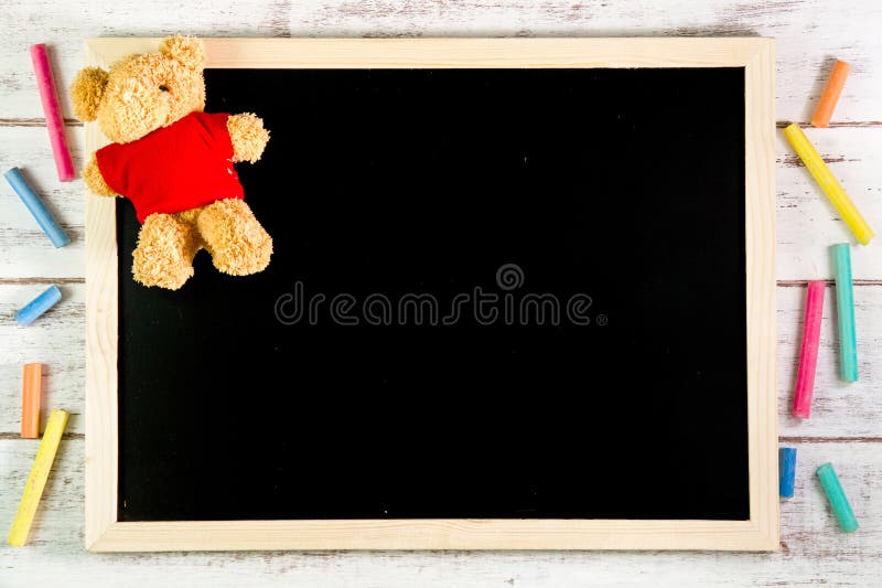 Blank blackboard and Teddy Bear on wooden table. Template mock up royalty free stock photography