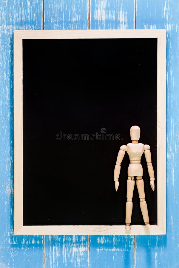 Blank blackboard and wooden puppet on wooden table. Template mock royalty free stock photos