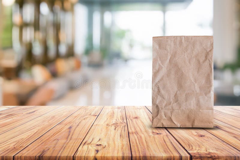 Blank brown paper bag for taking away food on wood table blurred abstract background interior view for branding mockup stock photos Blank brown paper bag for taking away food on wood table blurred abstract background interior view for branding mockup stock photos