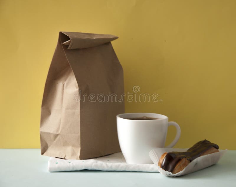 Blank brown paper bag and white coffee cup with chocolate cookies