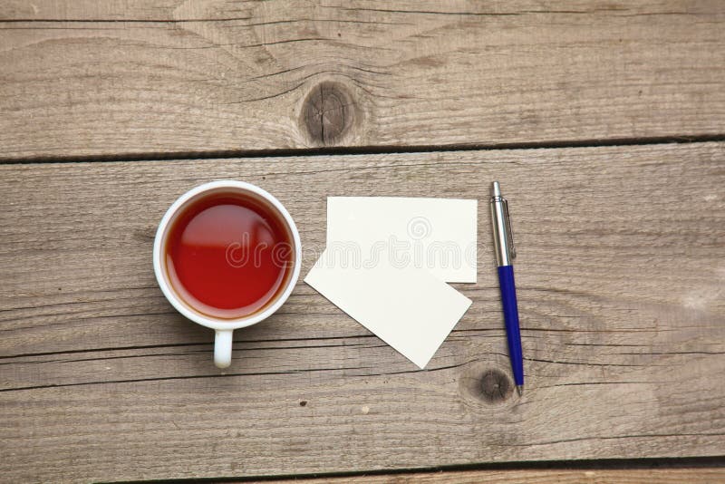 Blank business cards with pen and tea cup on