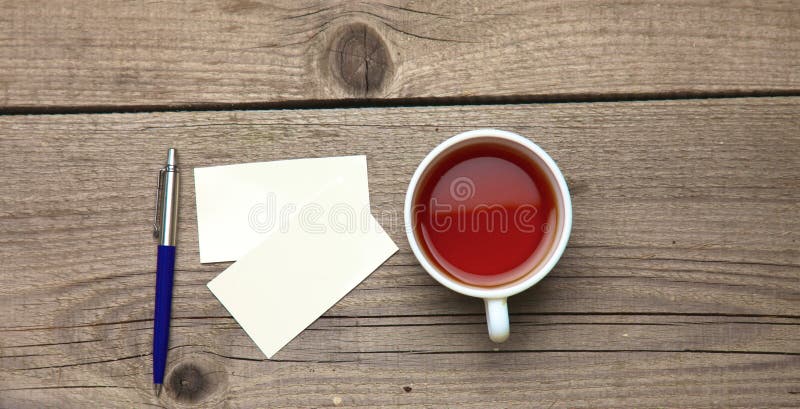 Blank business cards with pen and tea cup on