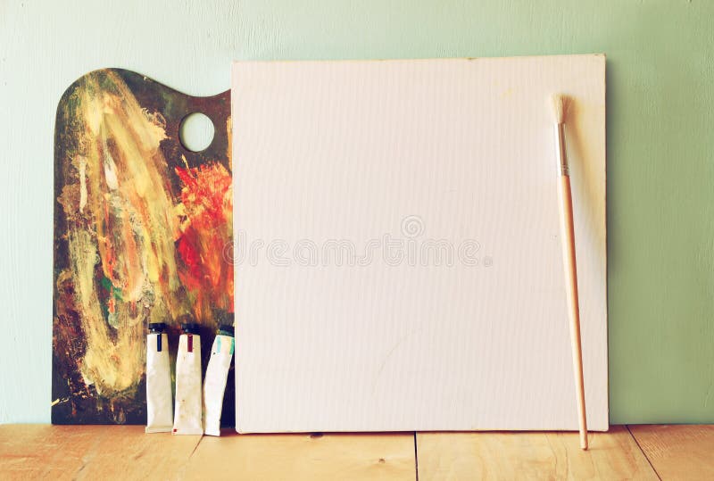 Blank canvas or poster with wooden palette on on wooden table and textured background