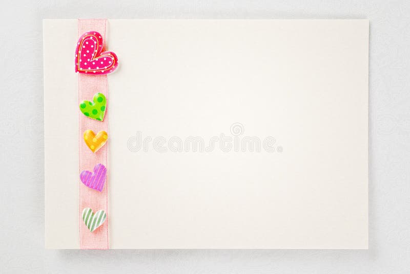 Blank card with colorful hearts over rose ribbon over ornamental paper background