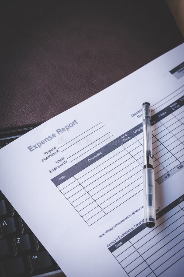 Blank Expense Report on Black Keyboard and Brown Leather Notebook on Pine Desk royalty free stock photography