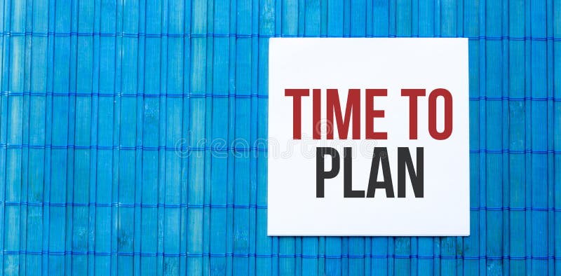 Blank note pad with text TIME TO PLAN on blue wooden background stock photos