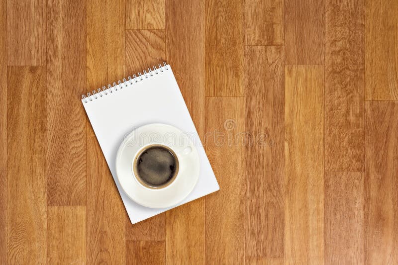 Blank notepad with office supplies and cup of coffee on wooden t