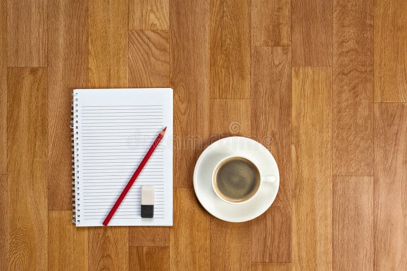 Blank notepad with office supplies and cup of coffee on wooden t