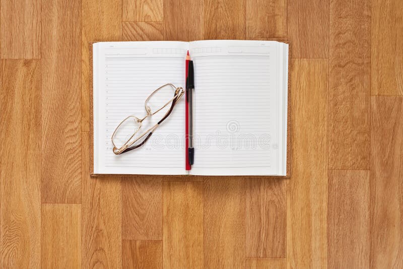Blank notepad with office supplies on wooden table.