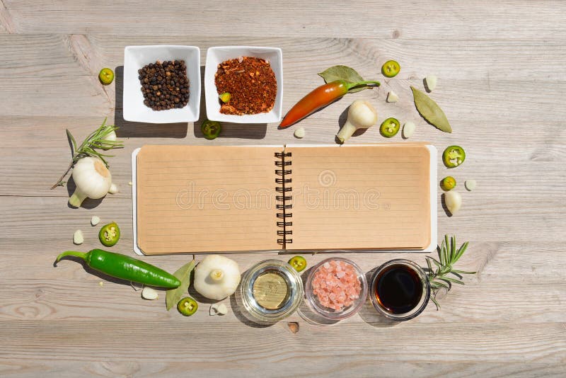 Blank open notebook for notes and pepper, bay leaf, rosemary, onions, Himalayan salt, olive oil, soy sauce on a. Gourmet, ingredients.