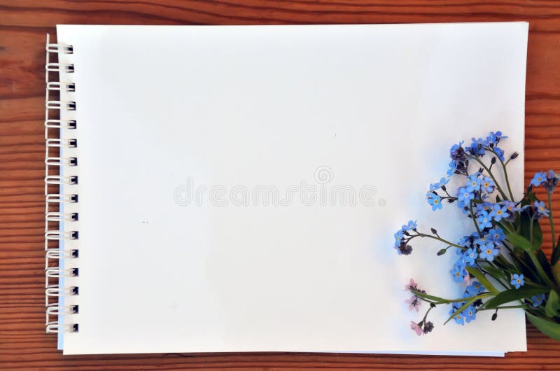 Blank page of a notebook and bouquet of forget-me-nots stock photo Blank page of a notebook and bouquet of forget-me-nots stock photo