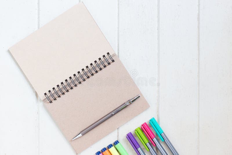 Blank paper notebook with many color highlighter on white wood board stock photo Blank paper notebook with many color highlighter on white wood board stock photo
