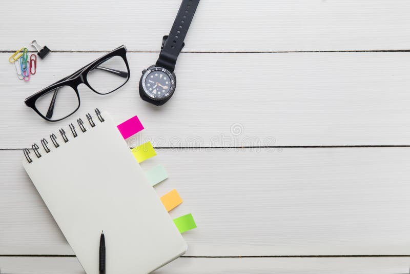 Blank paper notes with wristwatch on the table