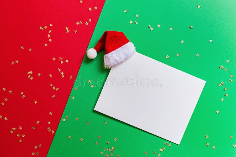 Blank of paper with Santa hat on red and green background with confetti. Christmas and new year concept. Greeting card, xmas. Paper blank, Santa hat on red and royalty free stock photography