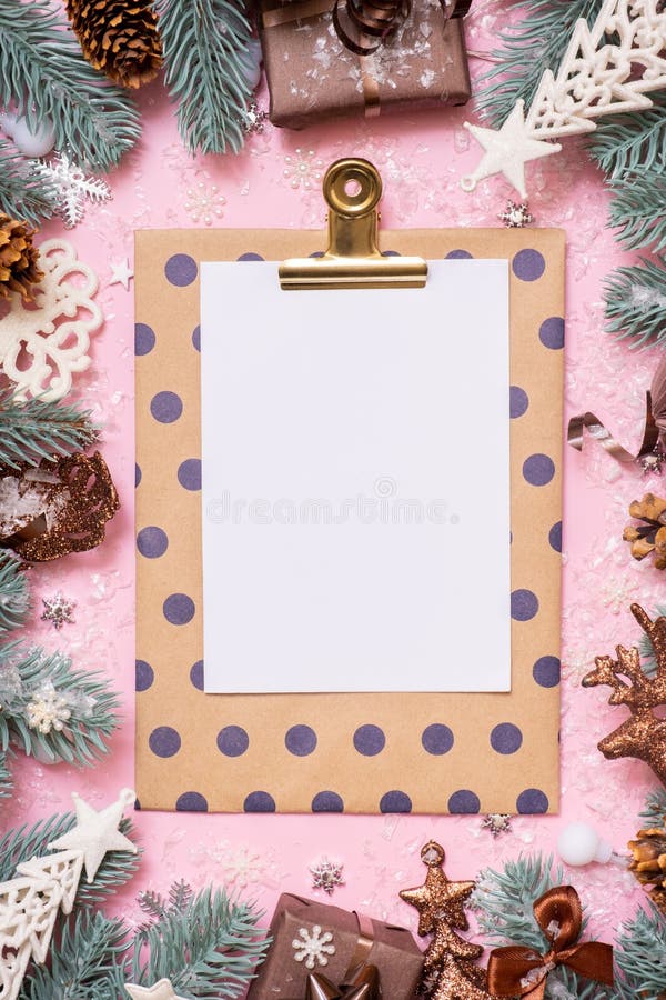 Blank paper on tablet with frame made frome pine tree branches and Christmas decoration in snow top view royalty free stock image