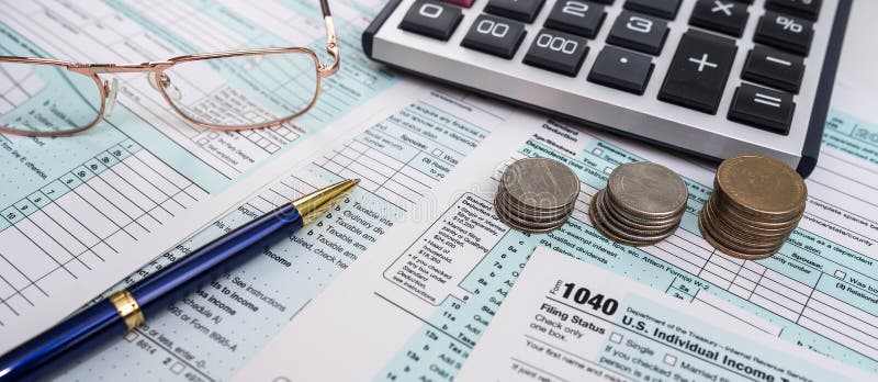 Blank personal income tax return with dollar bills and calculator and pen on calendar royalty free stock image