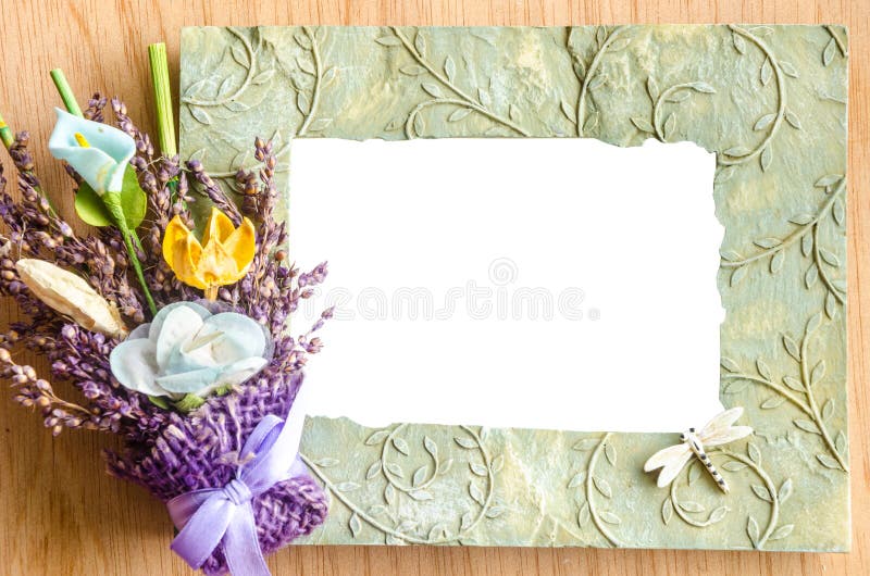 Blank photo frame and pink rose on wooden background.