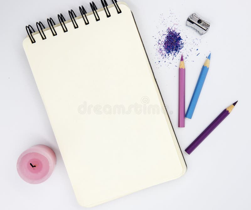 top view of a sketchbook with colored pencils arranged around on white  background Stock Photo by stoockking