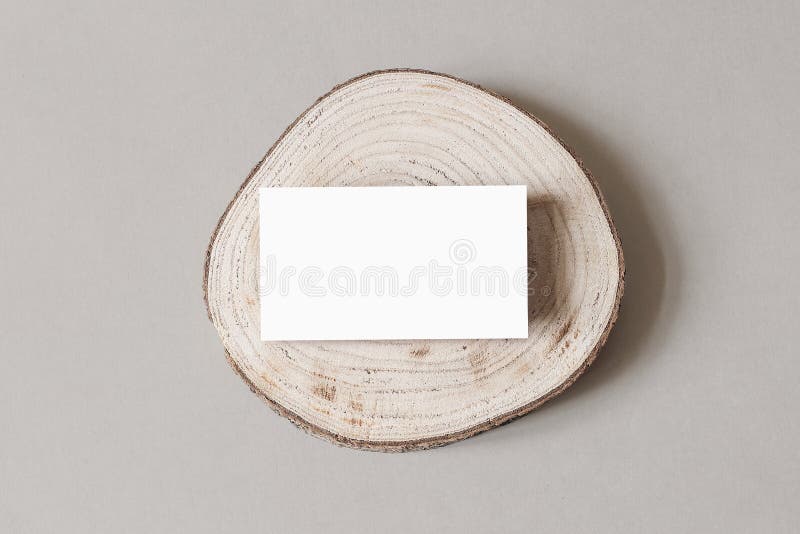 Blank white business card mockup on wooden plate, chop board. Grey table backgound. Modern minimalist template. Branding stock photo