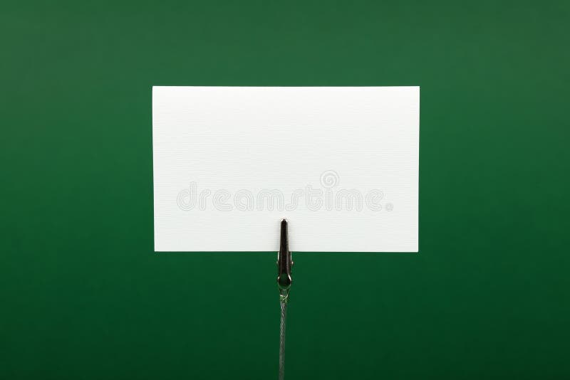 Blank white paper sign over green background