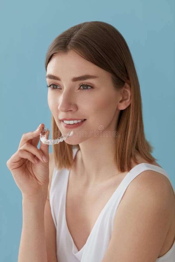 Blanqueamiento de dientes. Mujer con dientes saludables usando llaves extraÃbles foto de archivo
