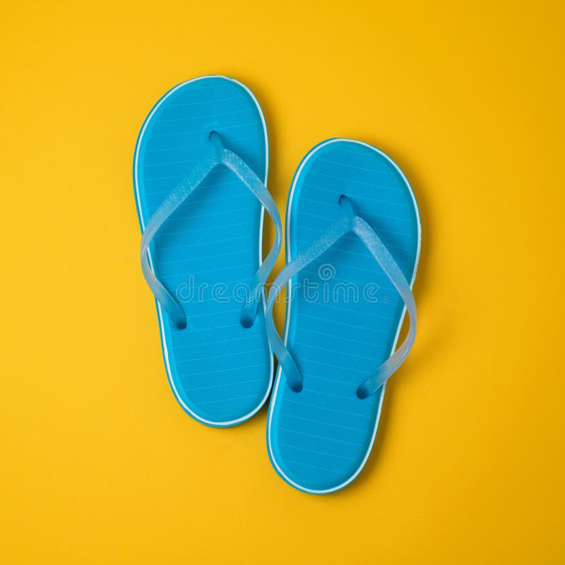 Minimal summer concept. Blue flip flops over yellow background. View from above. Minimal summer concept. Blue flip flops over yellow background. View from above