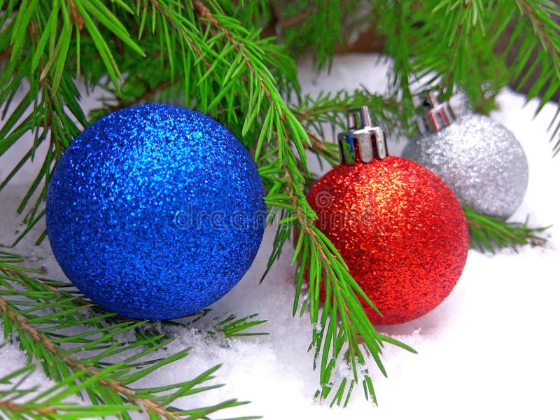 Blaue, rote und silberne Bälle des neuen Jahres mit grünem Tannenbaum auf schneebedecktem Hintergrund lizenzfreies stockfoto Blaue, rote und silberne Bälle des neuen Jahres mit grünem Tannenbaum auf schneebedecktem Hintergrund lizenzfreies stockfoto