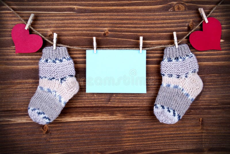 Blauer Aufkleber mit Baby-Socken und Kopien-Raum und Herzen lizenzfreies stockbild Blauer Aufkleber mit Baby-Socken und Kopien-Raum und Herzen lizenzfreies stockbild