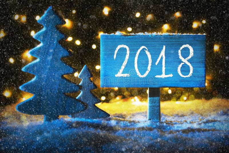 Sign With Text 2018 For Happy New Year. Blue Christmas Tree With Snow And Magic Glowing Lights In Backround And Snowflakes. Card For Seasons Greetings. Sign With Text 2018 For Happy New Year. Blue Christmas Tree With Snow And Magic Glowing Lights In Backround And Snowflakes. Card For Seasons Greetings.