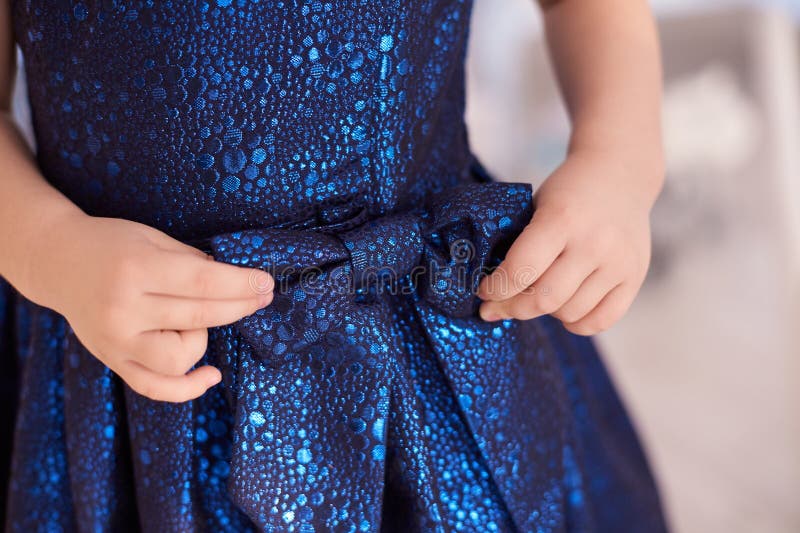 Blaues Kleid Großer Bogen Hände der Kinder horizontal stockfotografie Blaues Kleid Großer Bogen Hände der Kinder horizontal stockfotografie