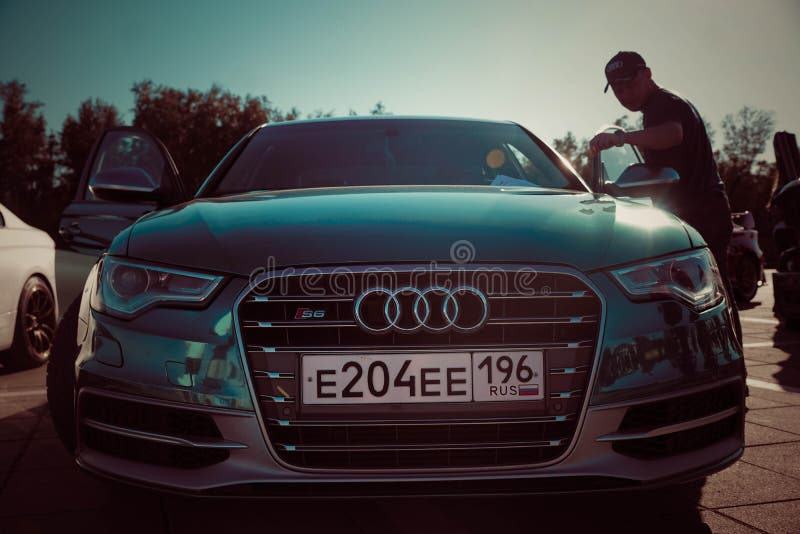 Blauwe auto en een mens bij de tentoonstelling van auto's in Rusland in de zomer royalty-vrije stock afbeeldingen Blauwe auto en een mens bij de tentoonstelling van auto's in Rusland in de zomer royalty-vrije stock afbeeldingen