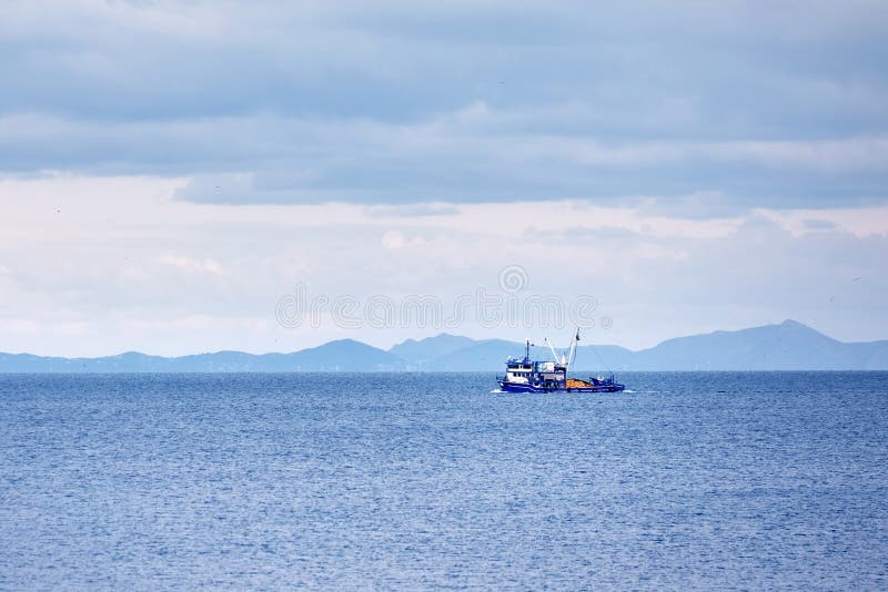 Blauwe treiler vissersboot die over het kalme overzees varen royalty-vrije stock fotografie Blauwe treiler vissersboot die over het kalme overzees varen royalty-vrije stock fotografie