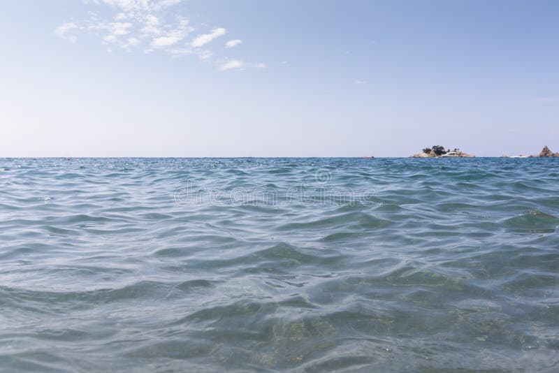 Seascape of turquois blue water and island in the distance at sea. Seascape of turquois blue water and island in the distance at sea