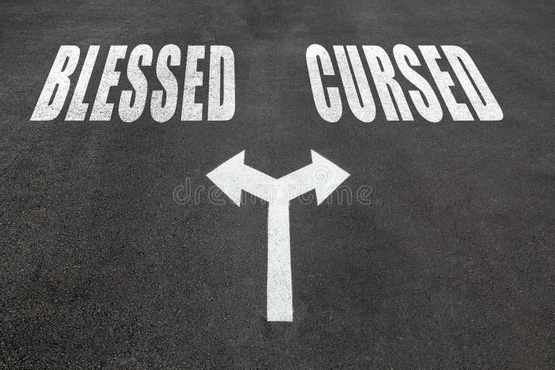 Blesed vs cursed choice concept, two direction arrows on asphalt. Blesed vs cursed choice concept, two direction arrows on asphalt.
