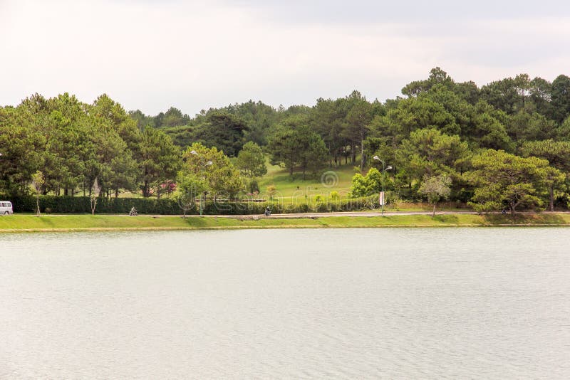 Da Lat, Vietnam - April 2016: A view of the green golf course across the Ho Xuan Huong lake in the hill town of Dalat. Da Lat, Vietnam - April 2016: A view of the green golf course across the Ho Xuan Huong lake in the hill town of Dalat