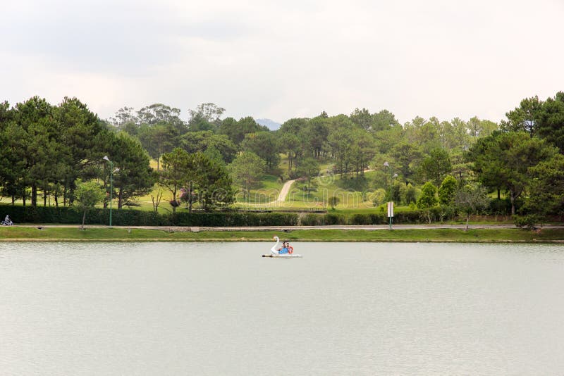 Da Lat, Vietnam - April 2016: A view of the green golf course across the Ho Xuan Huong lake in the hill town of Dalat. Da Lat, Vietnam - April 2016: A view of the green golf course across the Ho Xuan Huong lake in the hill town of Dalat