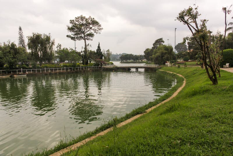 Da Lat, Vietnam - April 2016: A view of the green golf course across the Ho Xuan Huong lake in the hill town of Dalat. Da Lat, Vietnam - April 2016: A view of the green golf course across the Ho Xuan Huong lake in the hill town of Dalat