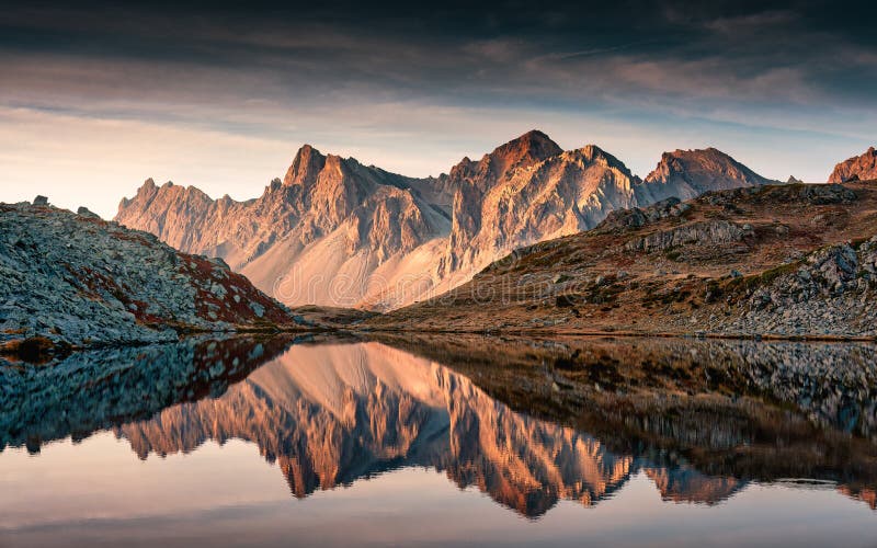 French alps landscape of Lac Long with massif Des Cerces reflection on the lake during autumn in Claree valley at Hautes Alpes, France. French alps landscape of Lac Long with massif Des Cerces reflection on the lake during autumn in Claree valley at Hautes Alpes, France