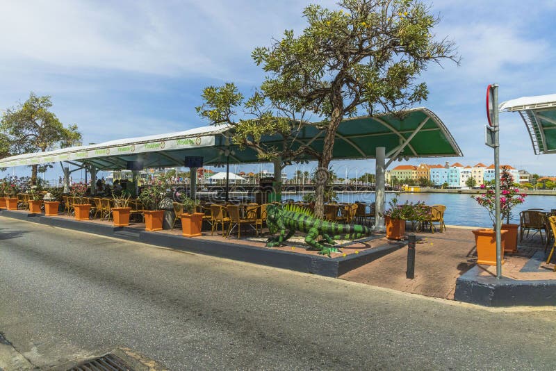 Blick auf die große grüne iguana Figur als Dekoration des Außenrestaurants Bucht von Saint Anna und farbenprächtige Gebäude im Hi