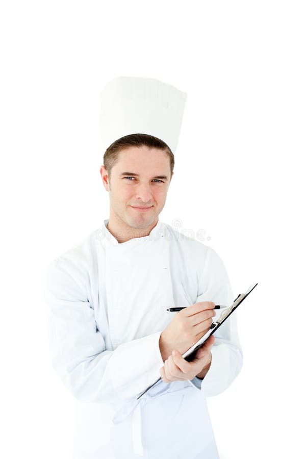 Blije jonge mannelijke kok die op een klembord schrijft stock afbeelding Blije jonge mannelijke kok die op een klembord schrijft stock afbeelding